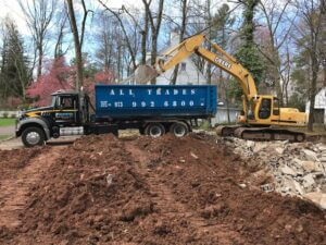 All Trades Dumpster being loaded with construction debris